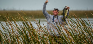 Man Raising Fish After Catching Fish During Fishing Tournament
